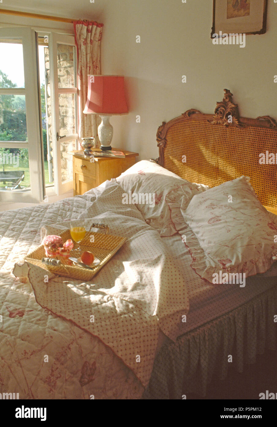 Rosa piumone e cuscini corrispondenti sul Bergere letto nel paese francese camera da letto Foto Stock