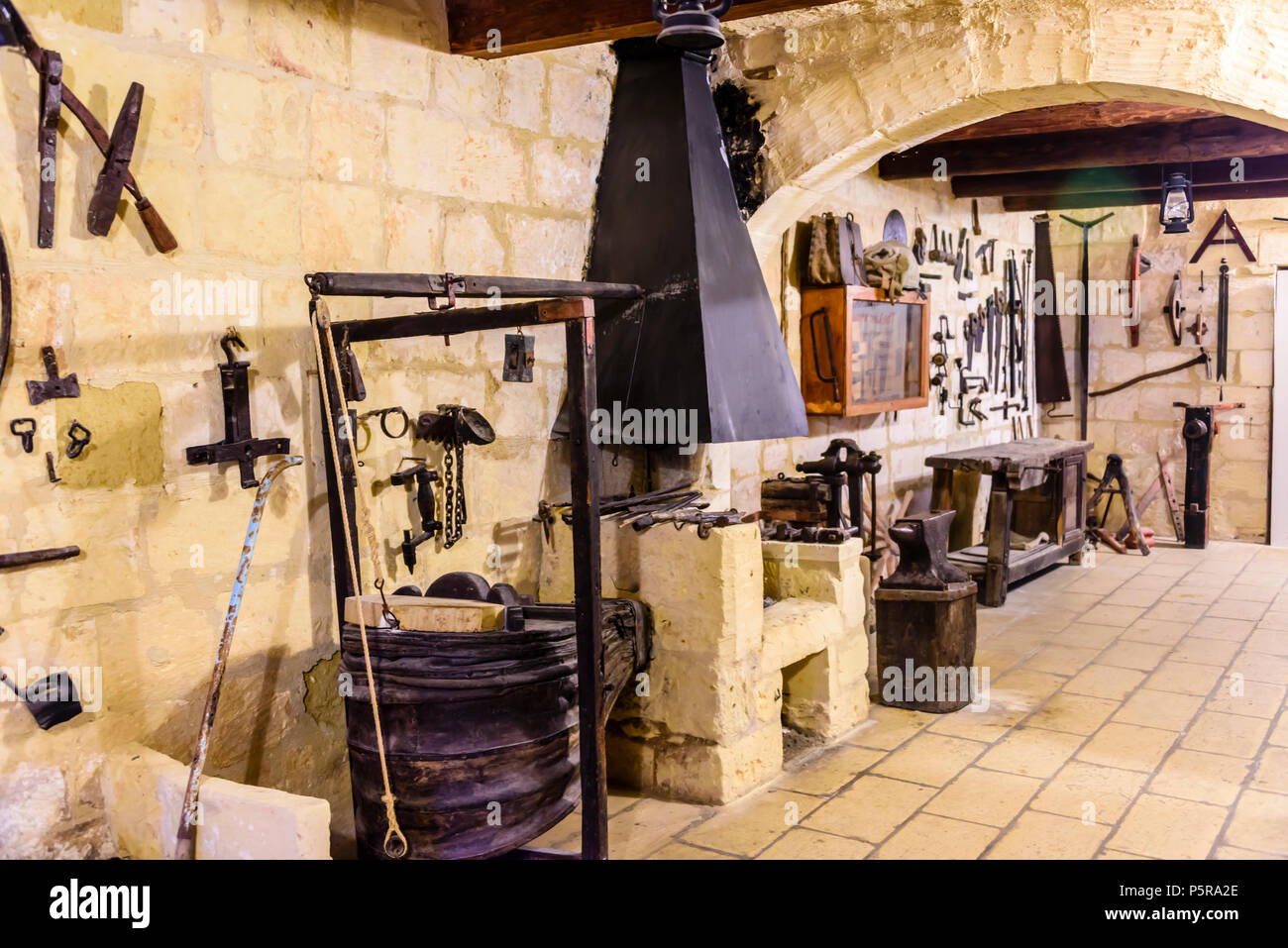 Vecchi strumenti tradizionali appeso a una parete in legno e metallo workshop di lavoro. Foto Stock