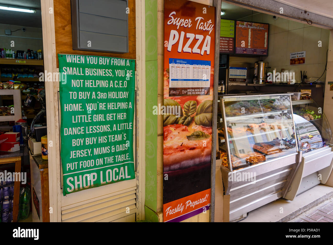Un segno a una pizzeria che incoraggia le persone a shop local dicono di non finanziare il ricco, ma aiutare famiglie locali. Foto Stock