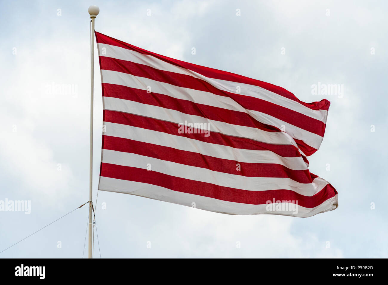 Una bandiera marittima a strisce rosse e bianche che batte contro un'ottusa e sovraimera day.in Malta. È stato utilizzato per identificare lo yacht 'Gloriana' Foto Stock