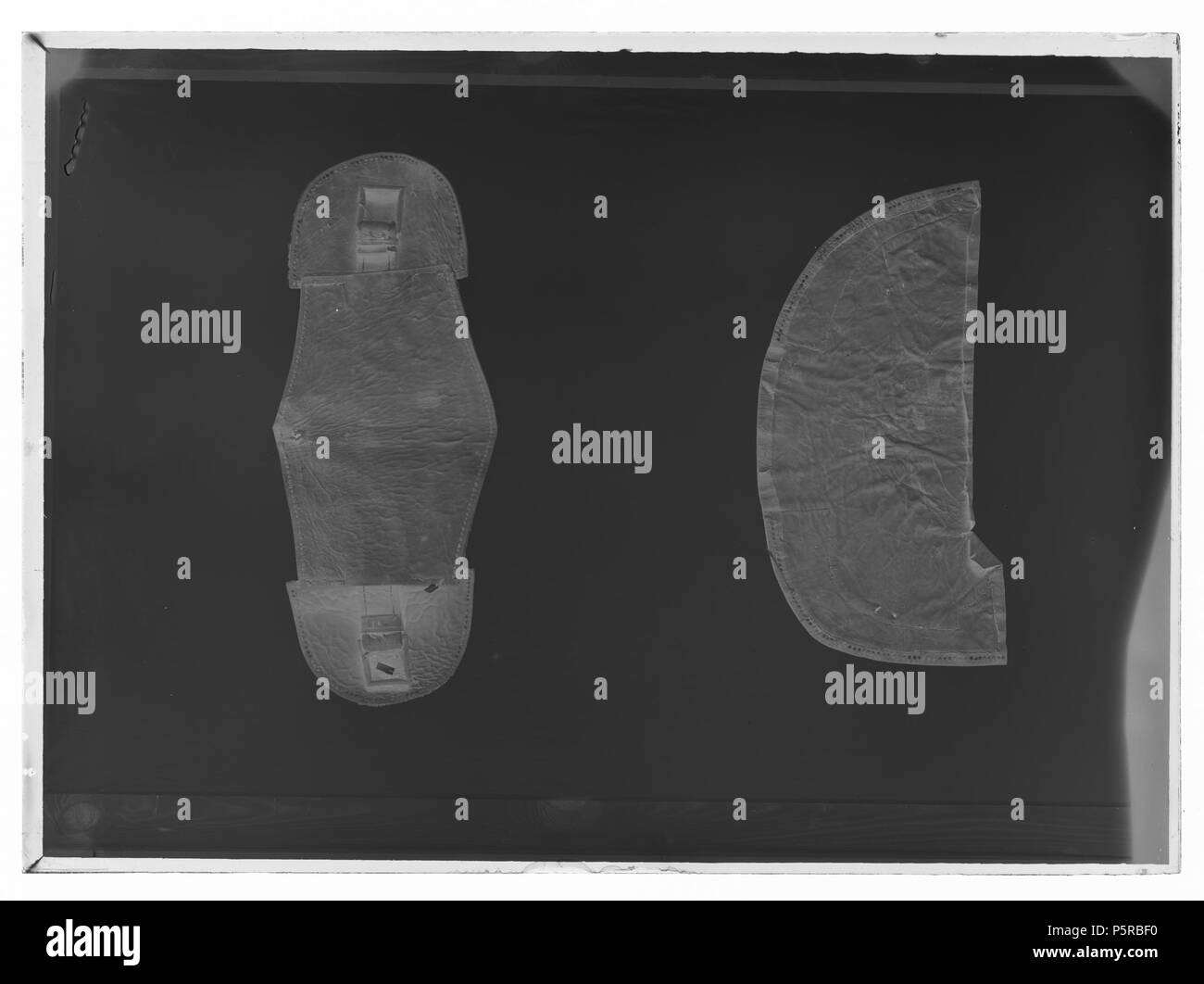 Dyna, sadelputa. Svenska: Dyna av fem kläde lager, som något minskar, ho rektangulär forma med rundade hörn. Utdragna Två kanter på varje sida. Lagren i olika färger, nerifrån och upp: röd, blå, Gul, röd, grön. Ovanpå två halva skinnrundlar av skinn rött, som följer dynans forma, höjd: 570 mm, bredd: 290 mm. De rundade hörnen dekorerade med stiliserade växtslingor på mörkröd sammet. Broderi silvertråd av mi plattsöm på formklippt ljust skinn. Hörnen dessutom kantade av en tofsliknande franskant i rött, gult, beige, vitt och blått. Skinnrundlarna är fästa med 13 svarta snören som på undersidan av Foto Stock