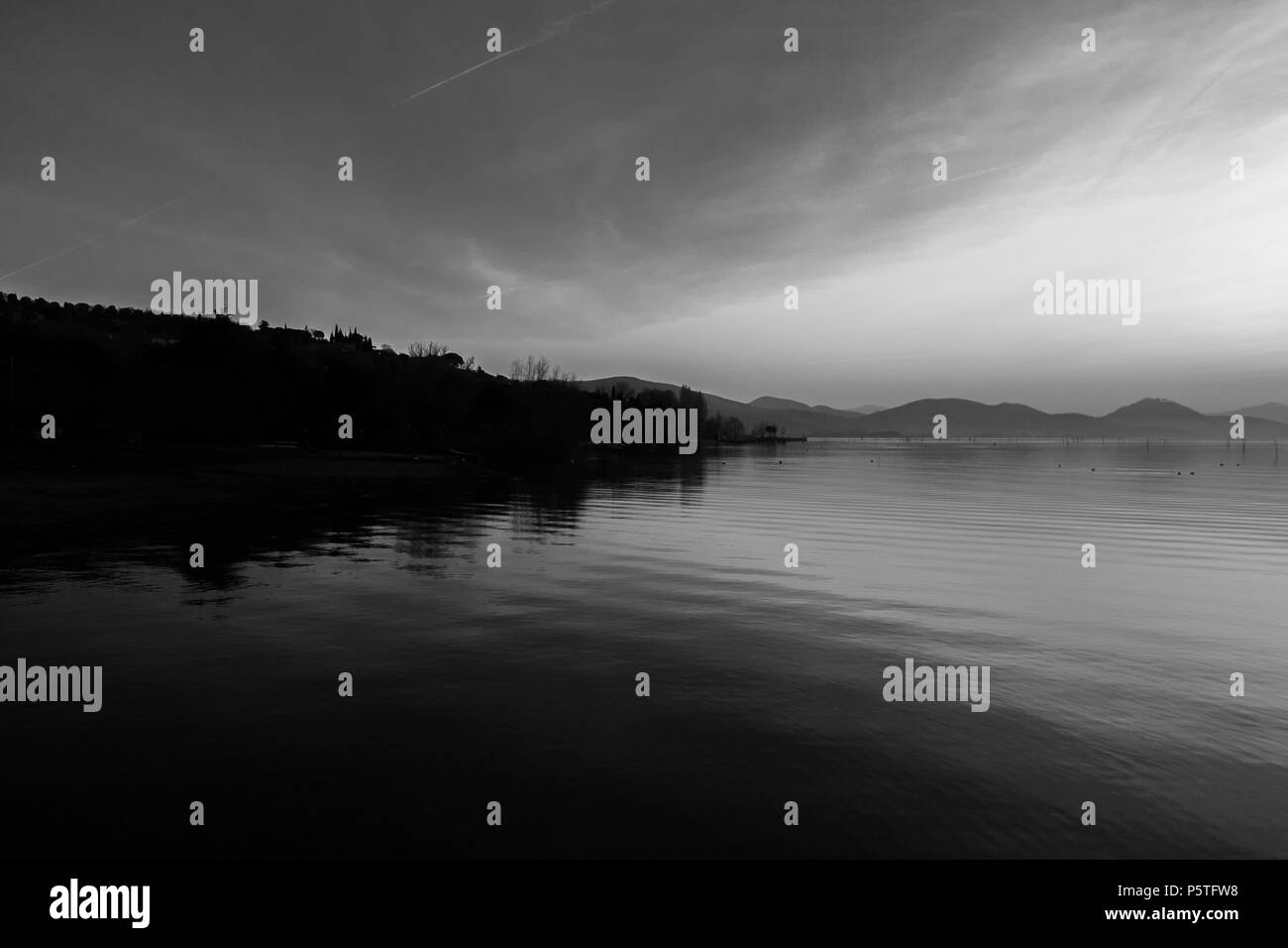 Bellissima vista del lago Trasimeno (Umbria, Italia), con colline e cielo riflettendo sull'acqua Foto Stock