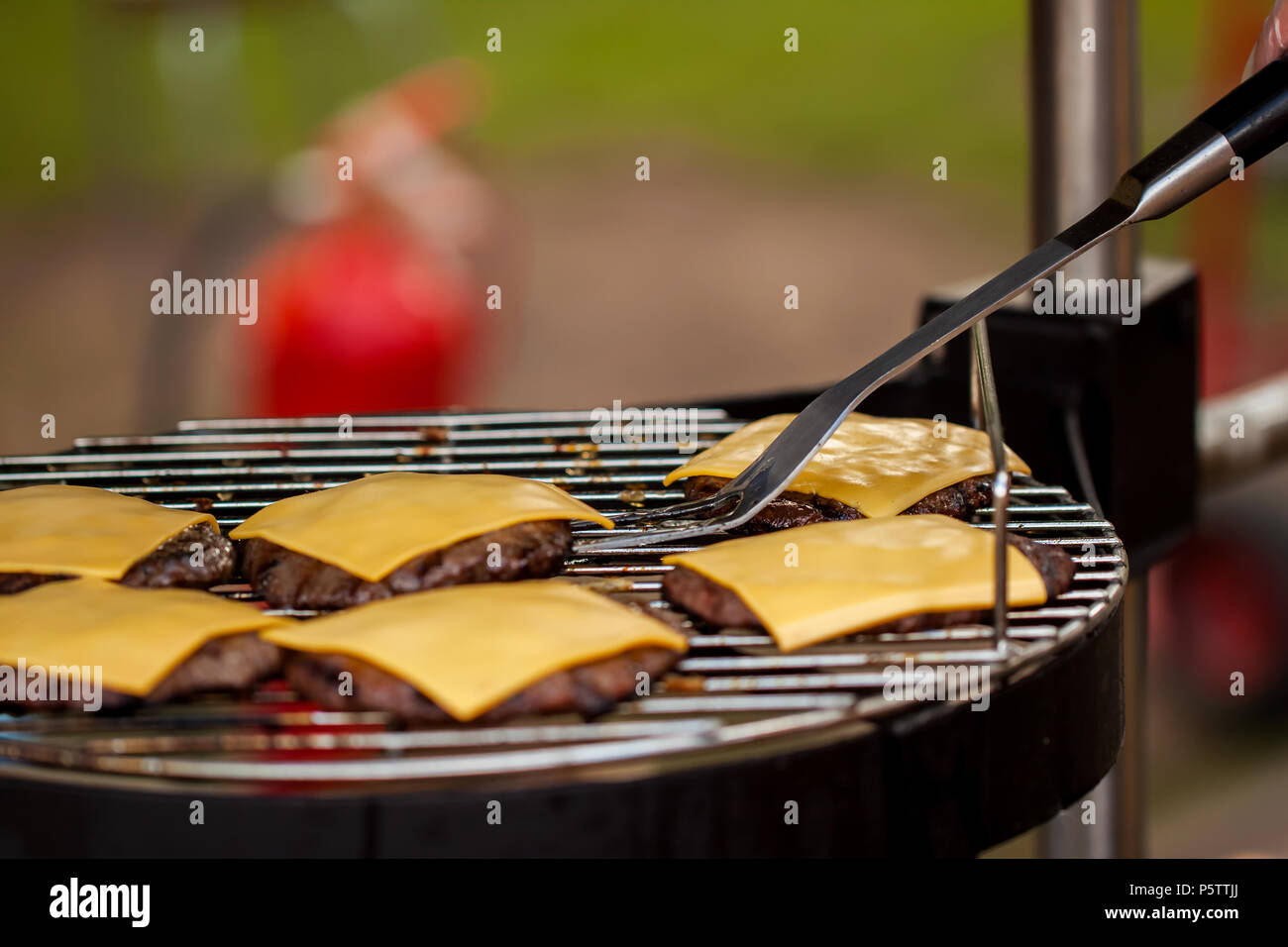 Preparazione di cheeseburger sulla famiglia giorno barbecue Foto Stock