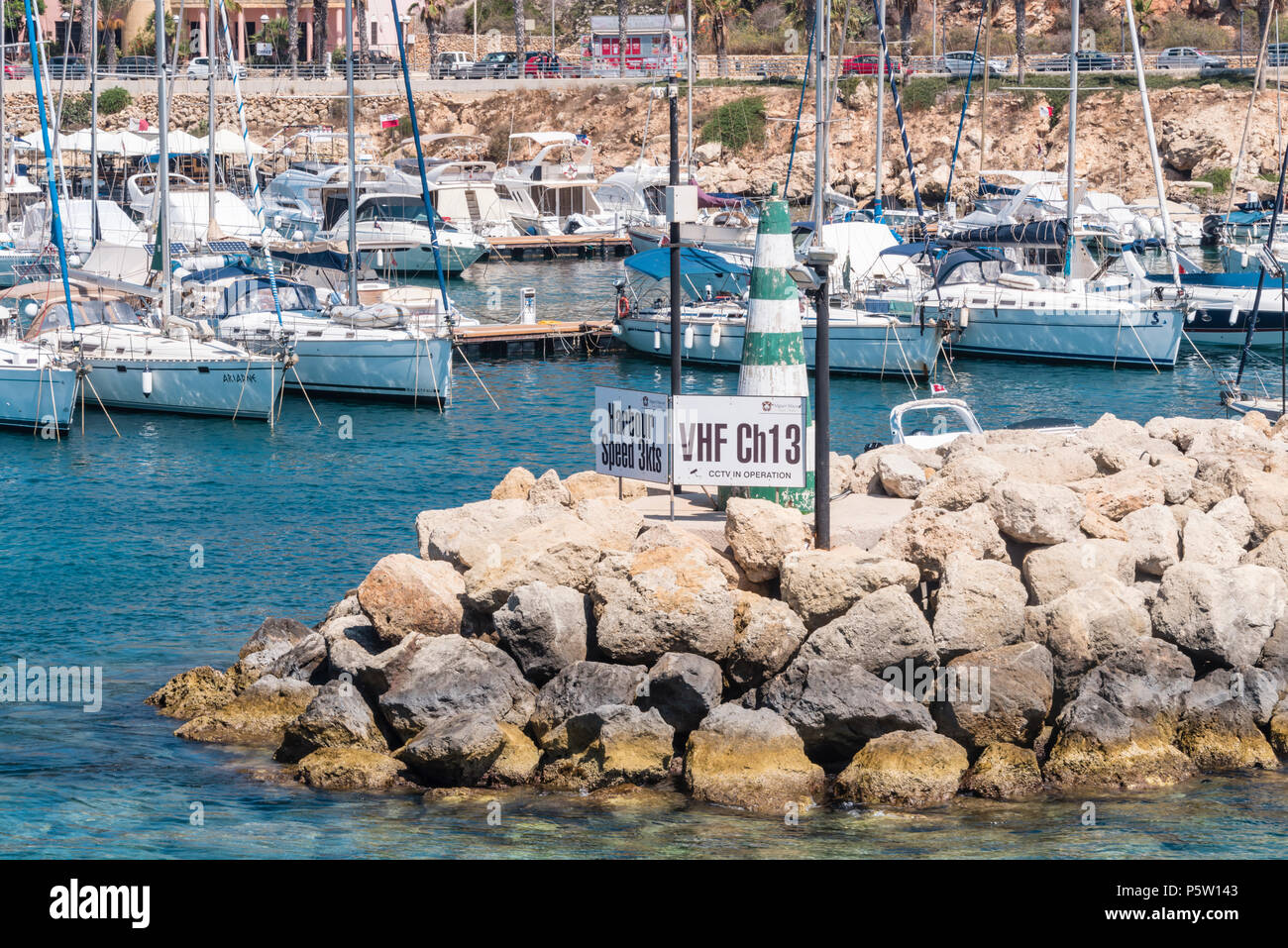 Firmare all'entrata di Mgarr harbour che mostra un 3kts limite di velocità,  e la radio VHF canale marino (CH13) per la porta. Mgarr a Gozo, Malta Foto  stock - Alamy