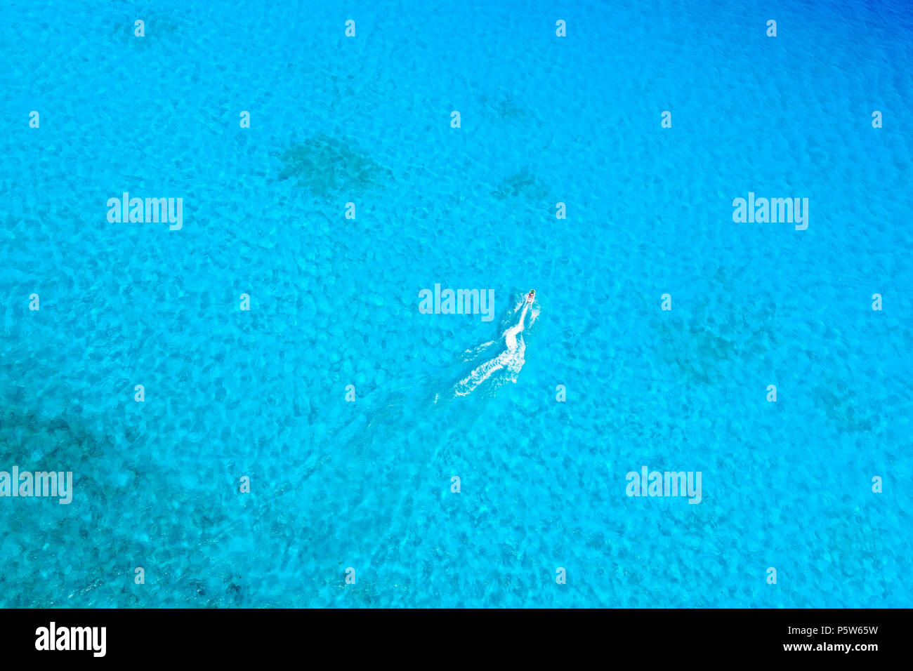 Birds Eye view di getto sci equitazione a blu oceano tropicale. Foto Stock