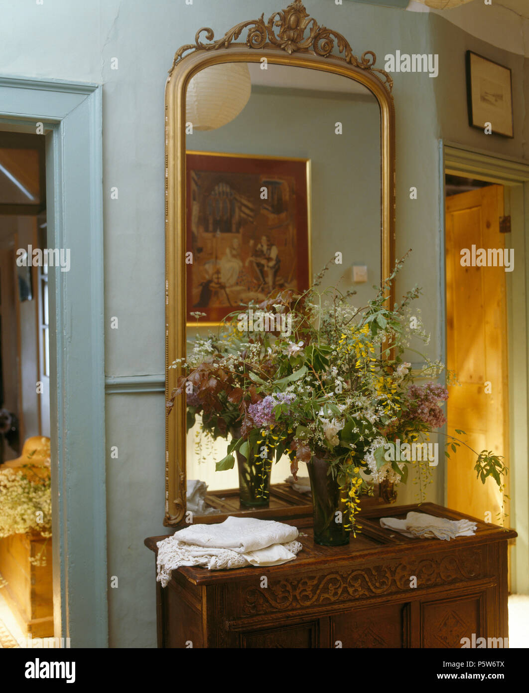 Grande ed antico specchio dorato al di sopra di legno intagliato armadio in  grigio-blu paese hall Foto stock - Alamy