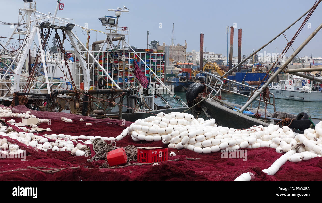 Attività di pesca i pescherecci con reti da traino e le barche nel dock a Essaouira, Marocco. Alcuni pronto per essere riparati e re-installato. Foto Stock