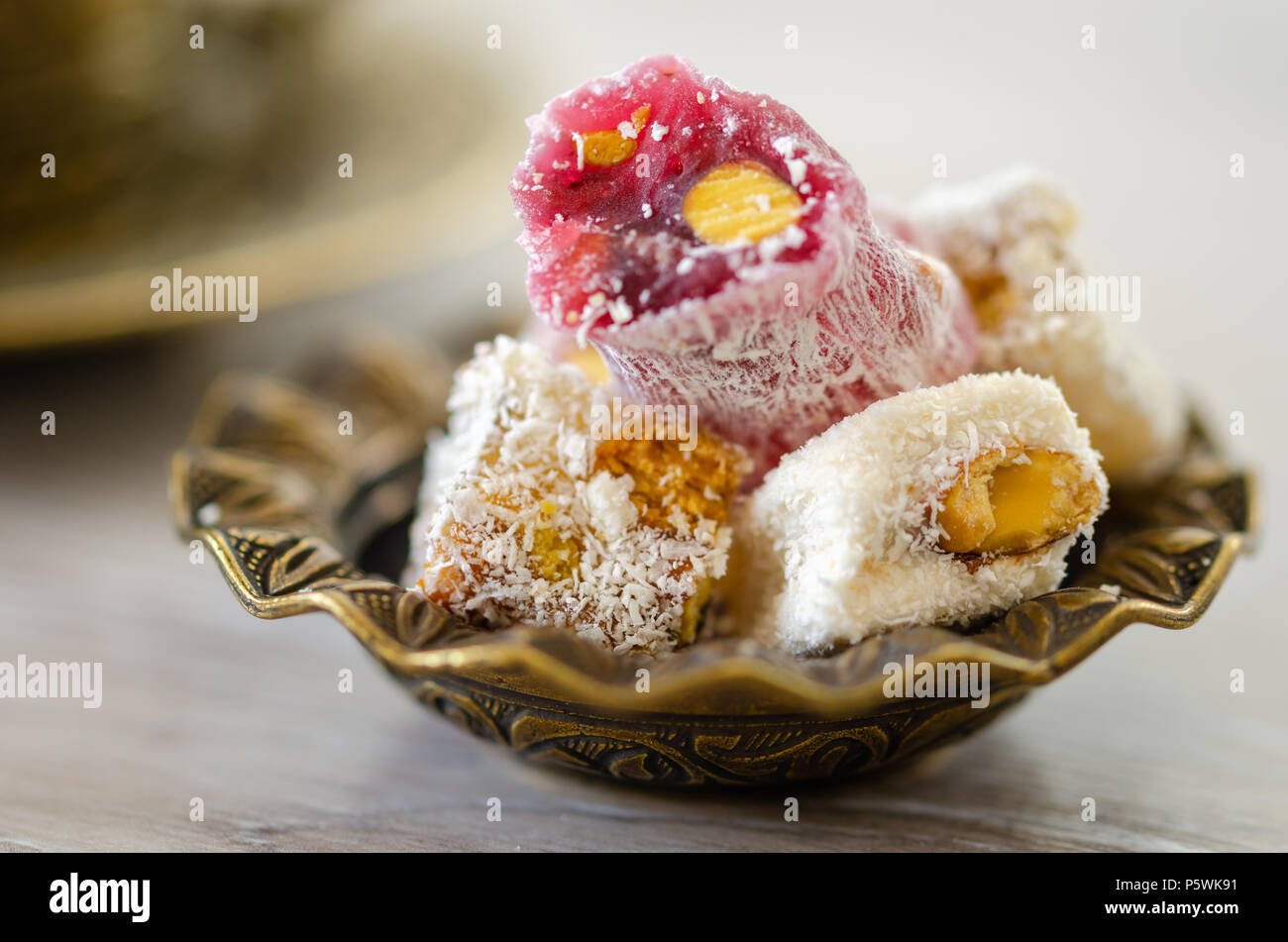 Turkish Delight con pistacchi in tradizionale scolpiti a motivi geometrici piastra in metallo,chiarezza selettiva,profondità di campo Foto Stock