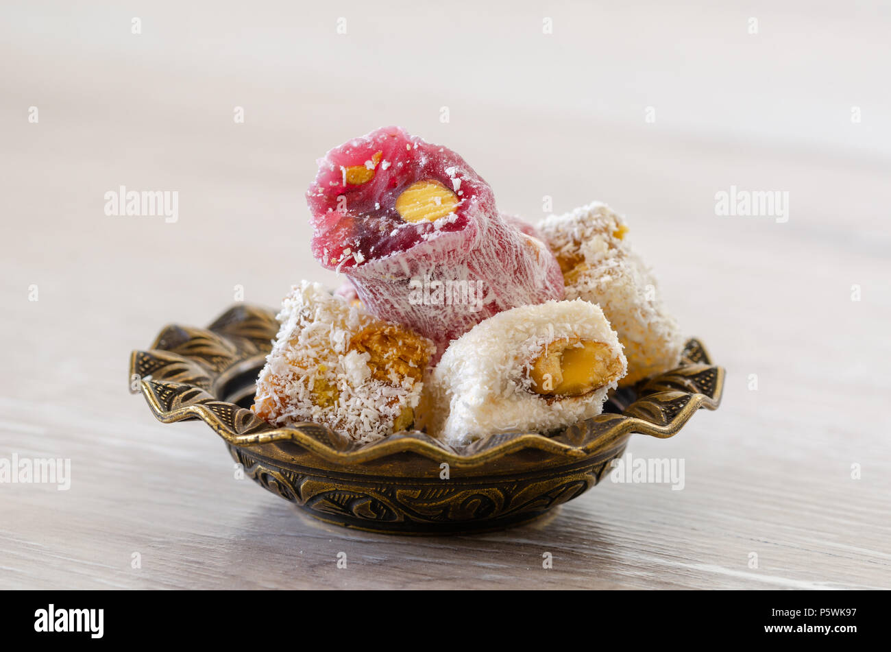 Turkish Delight con pistacchi in tradizionale scolpiti a motivi geometrici piastra in metallo,close-up,isolato. Foto Stock