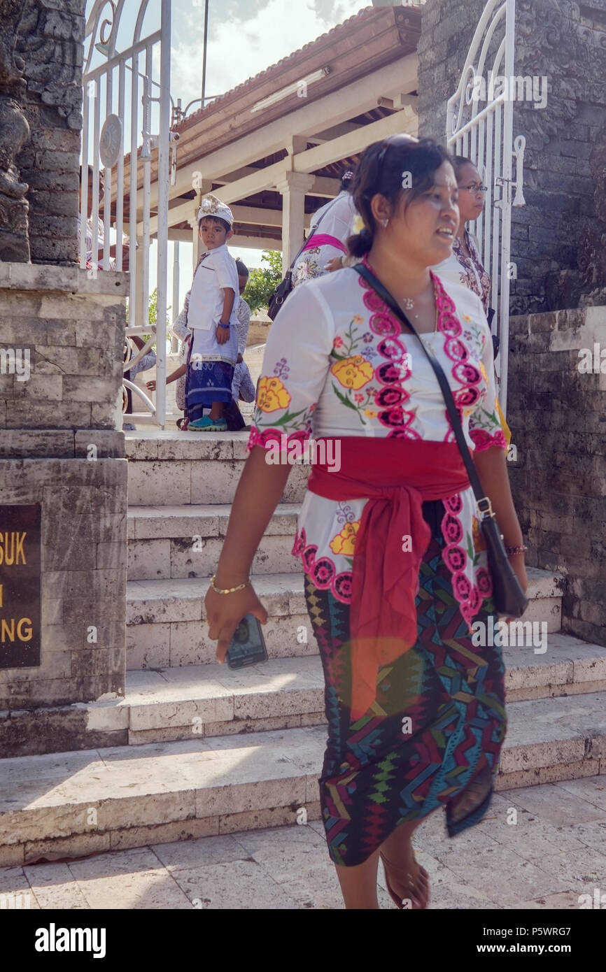 Cerimonia al modello di Uluwatu, Bali, donna e ragazzo in costumi indù Foto Stock