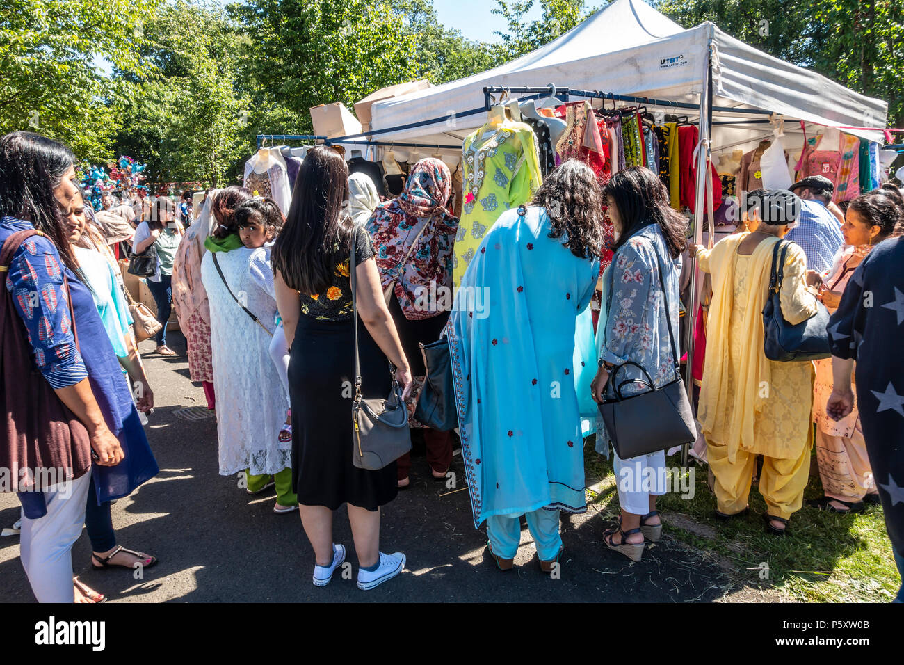 Gruppo di Punjabi-Scots principalmente le donne alla ricerca di capi di abbigliamento tradizionale nel bazaar a Glasgow Mela, 2018 in Kelvingrove Park nella città del West End Foto Stock