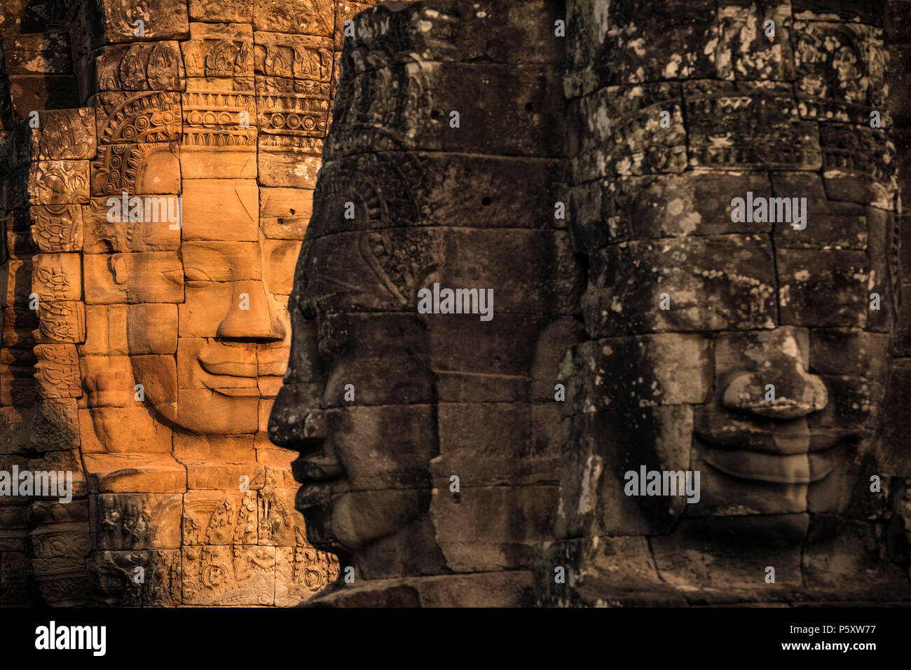 Sun illuminare un volto in le tempio Bayon in Cambogia Foto Stock