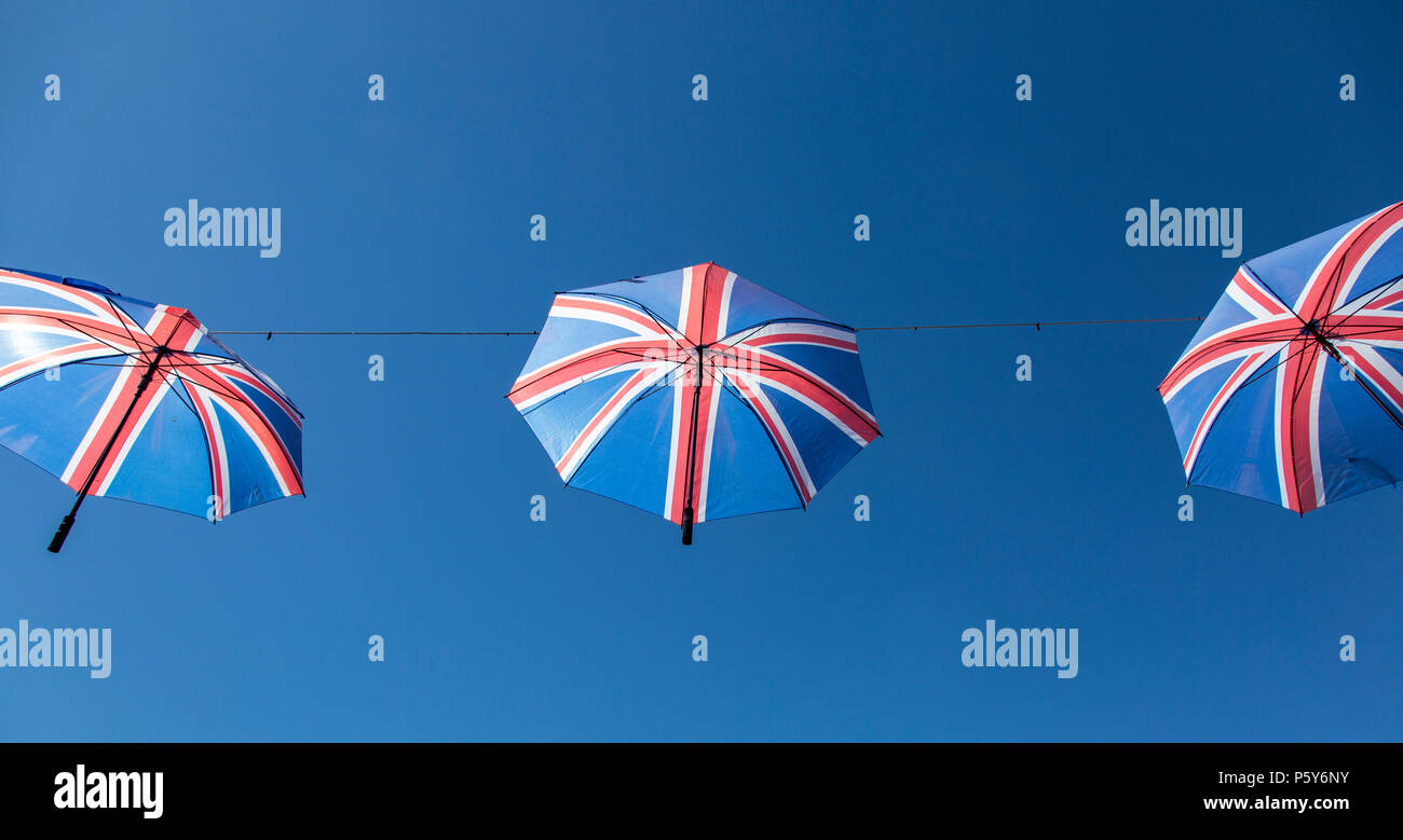 Ombrelli con bandiera britannica sospesi contro un cielo azzurro Foto Stock