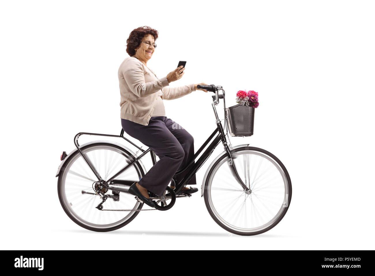 Donna anziana in sella ad una bicicletta e guardando il suo cellulare isolato su sfondo bianco Foto Stock