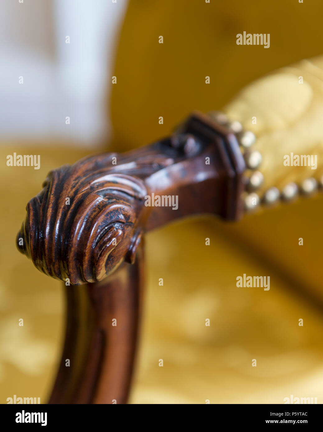 Dettaglio della poltrona in legno con tappezzeria di colore giallo Foto Stock