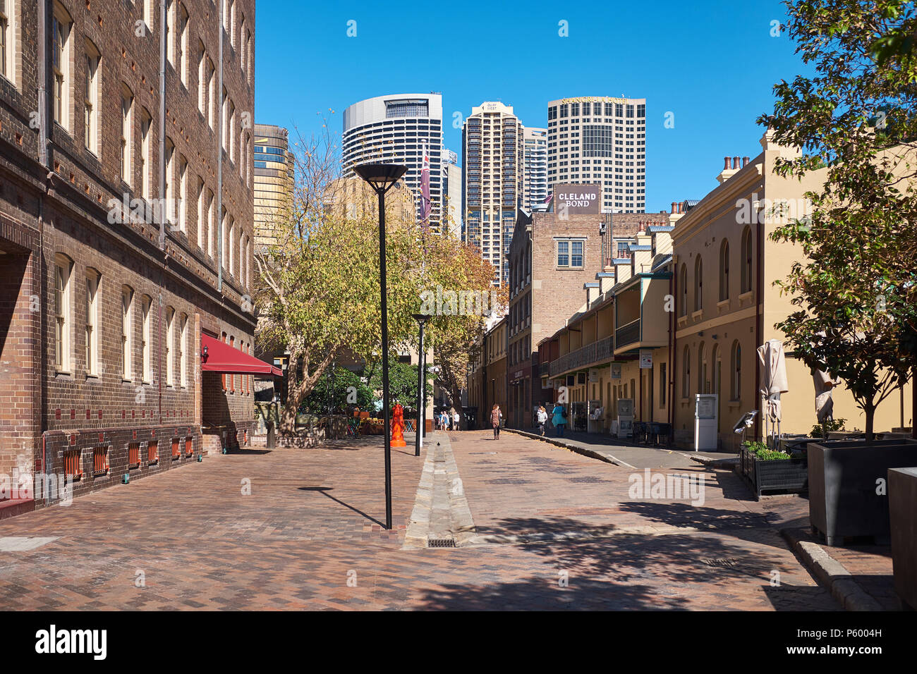 Una street view di Playfair strada nell'area Rocks di Sydney con alti edifici moderni di Sydney dietro su un soleggiato e limpido cielo blu giorno Foto Stock