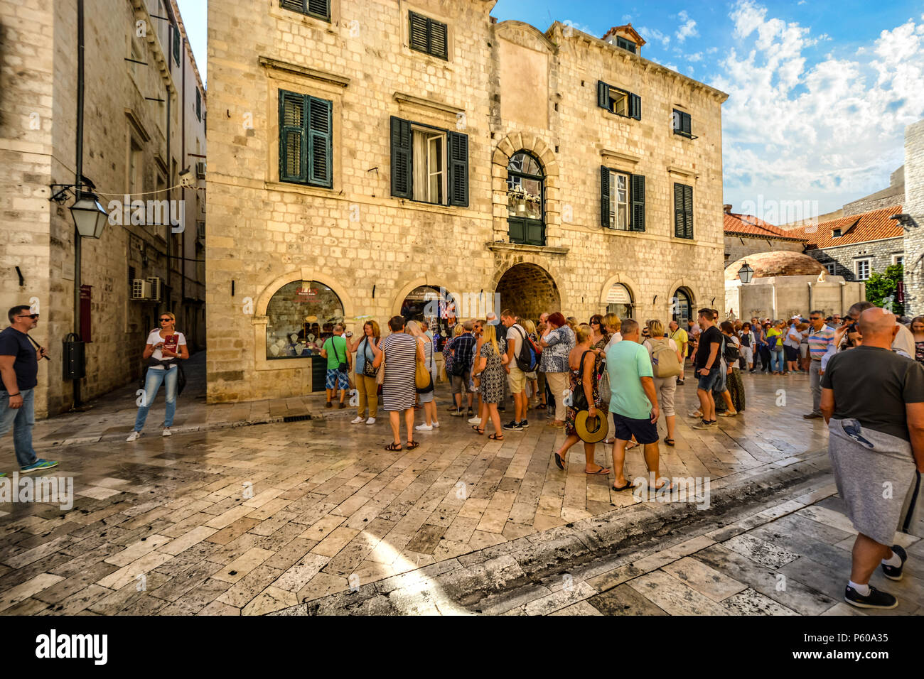 I turisti sui principali Stradun, la strada principale attraverso le mura della città di Dubrovnik Croazia con l'Onofrio Fontana a distanza Foto Stock