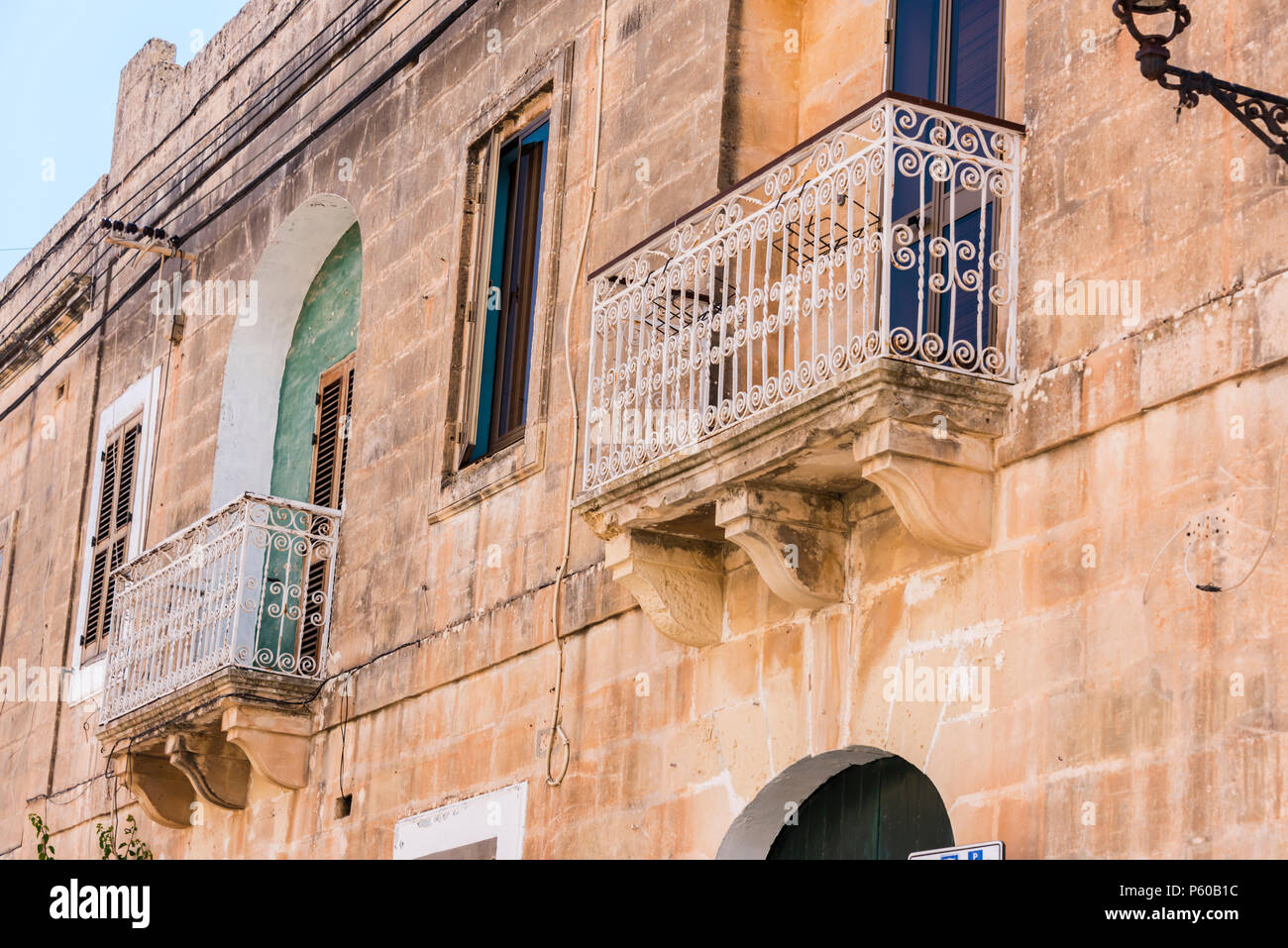 Tradizionali balconi in ferro battuto su un edificio nel piccolo villaggio maltese di Gudja, Malta. Foto Stock