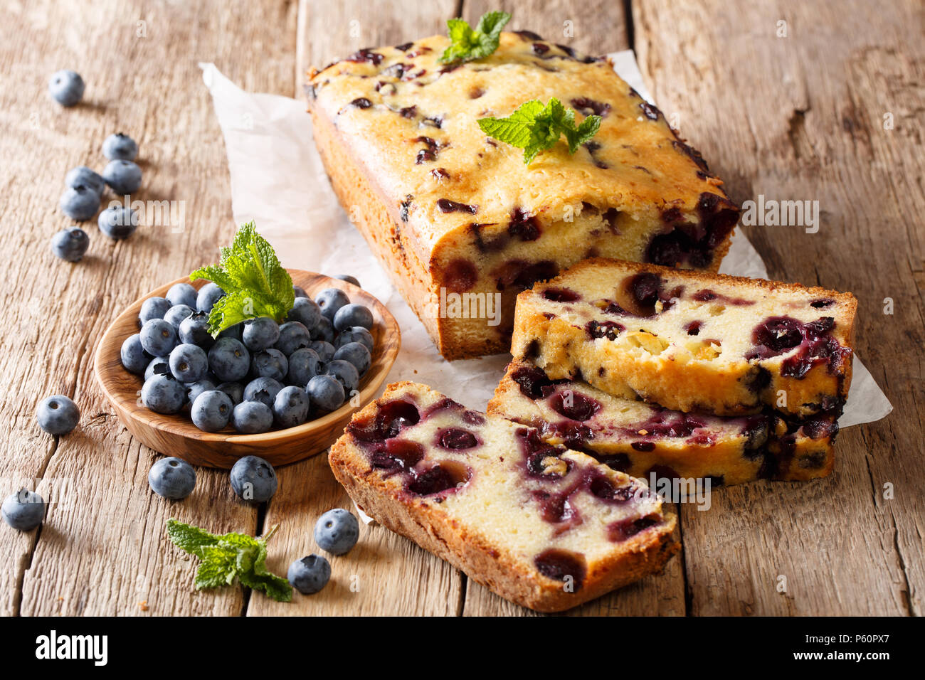 Estate di pane fresco muffin ai mirtilli torta di pane decorate con la menta closeup su una tavola orizzontale. Foto Stock