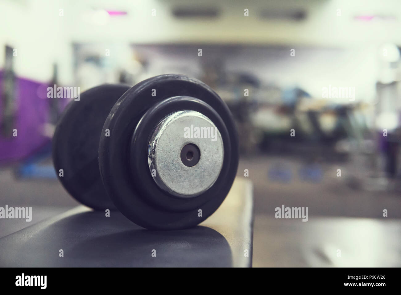 Le righe dei pesi nella palestra con altissimo contrasto e tonalità di colore. manubrio in gomma su un banco di lavoro sullo sfondo della palestra per la formazione. il concetto di b Foto Stock