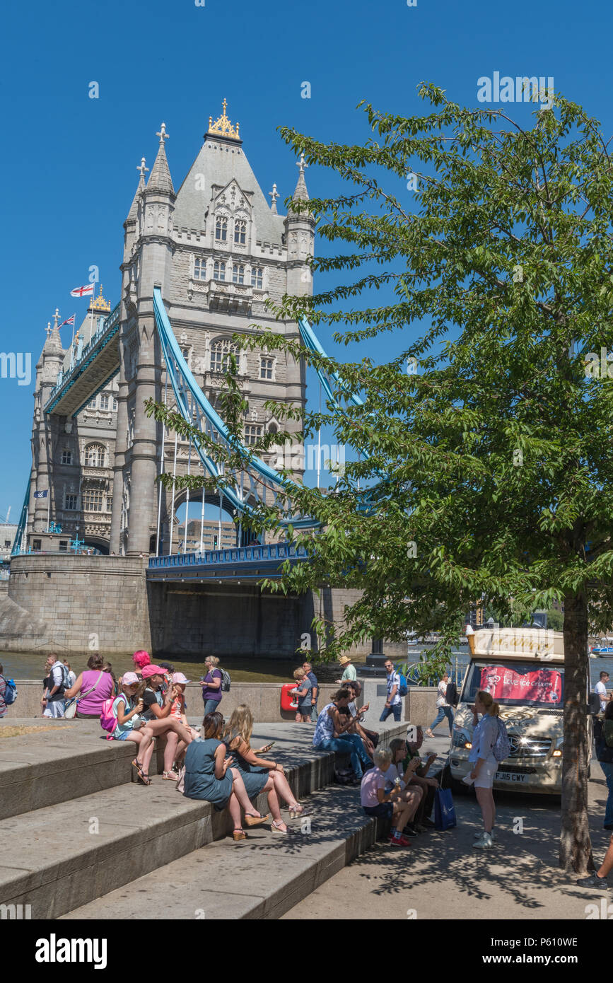 Lond, REGNO UNITO, 27 giugno 2018. L'ondata di caldo continua nel centro di Londra con il cielo limpido e potenzialmente battere i record di temperature. La folla di turisti e gli impiegati a più luogo di Londra e al Tower Bridge godendo il caldo e il bel sole seduto sull'erba e prendere il sole. Credito: Steve Hawkins Fotografia/Alamy Live News Foto Stock