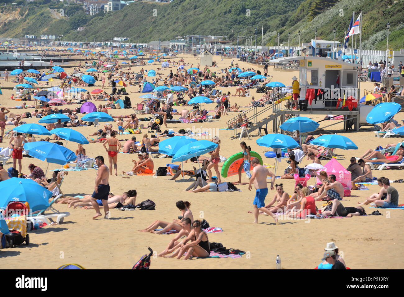 Bournemouth Dorset, Regno Unito, 2018 ondata di caldo. La gente sulla spiaggia di sabbia sulla costa sud dell'Inghilterra durante la stagione calda. Foto Stock