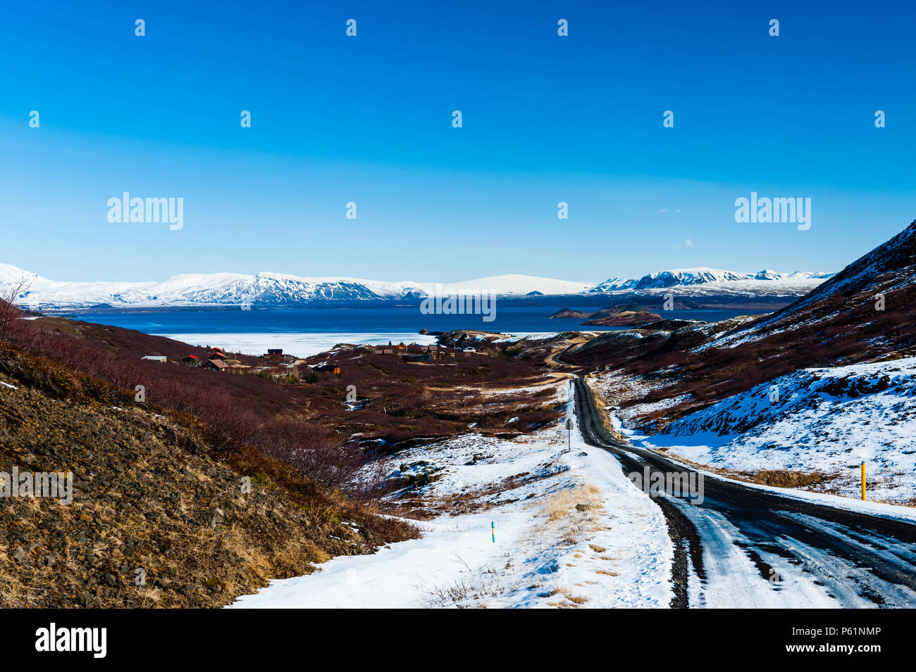 In parte coperta di neve strade di ghiaia conduce alla riva del lago thingvallavatn a Thingvellir national park, catturato in buone condizioni meteorologiche, Islanda aprile 2018 Foto Stock