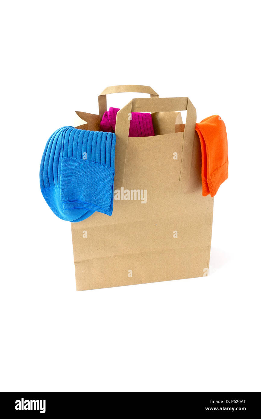 Tre paia di moderni e vivaci calze colorate appesa sopra la parte superiore di un sacchetto di carta. Foto Stock