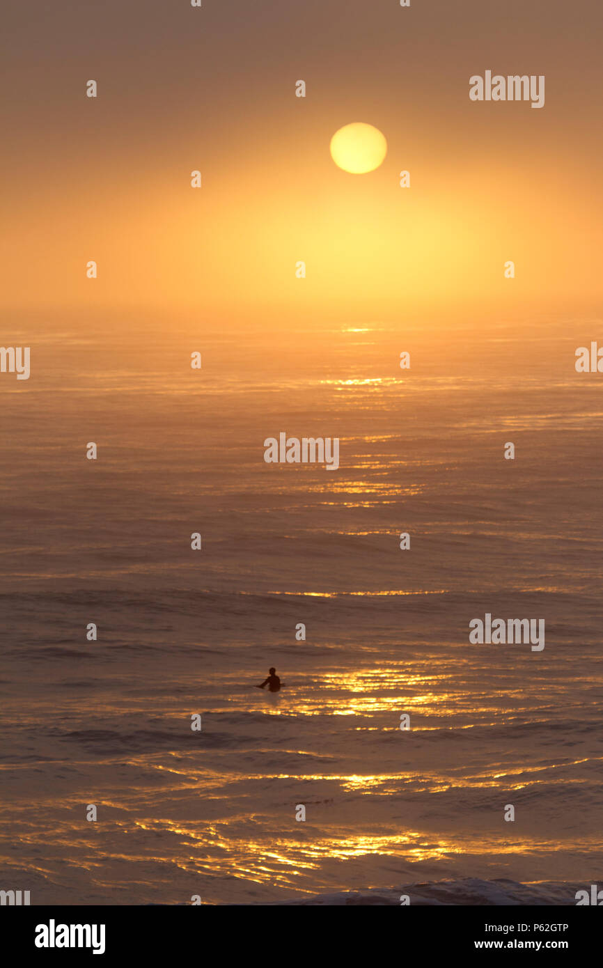 Impostazione di sole attraverso la nebbia sull'Oceano Pacifico Foto Stock