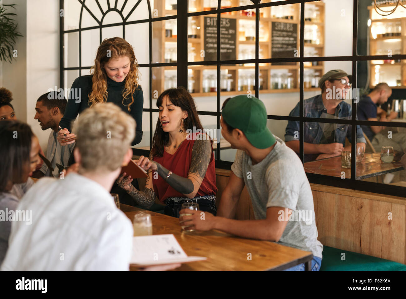 Diversi gruppi di amici ordinare del cibo in un elegante bistrò Foto Stock