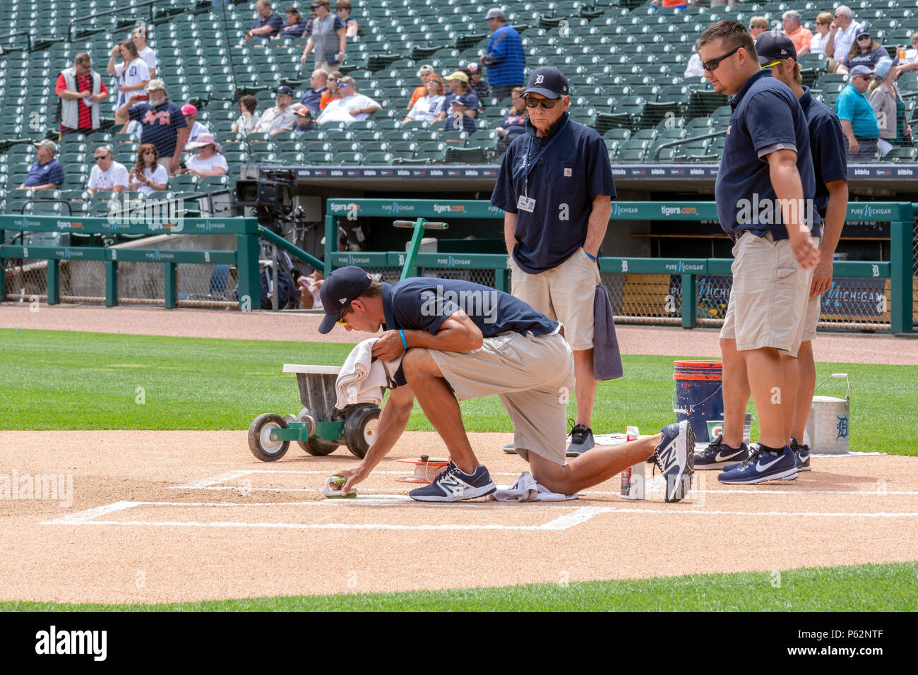 Detroit, Michigan - tre membri dei motivi di equipaggio guardare come uno scrubs home piastra prima di una partita di baseball al Comerica Park, casa di Detroit Tige Foto Stock