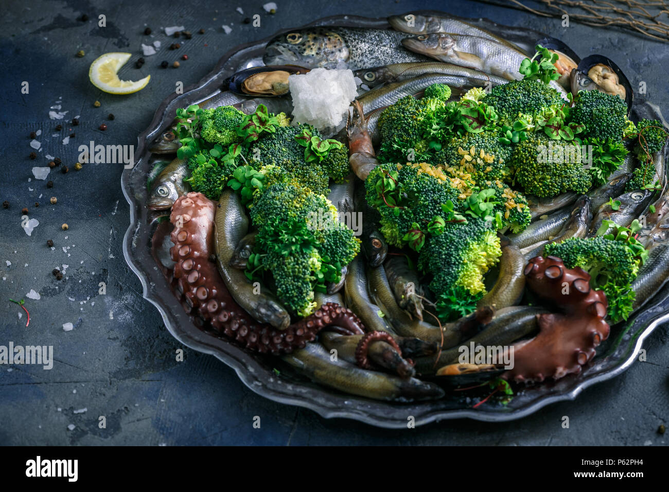 Pesce crudo, polpo, s.gamberetti e cozze su una piastra con verdure Foto Stock