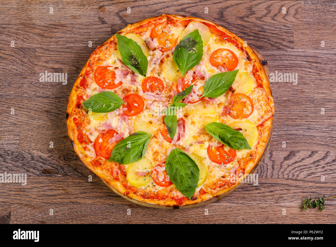 Pizza con prosciutto e patate servita il basilico Foto Stock