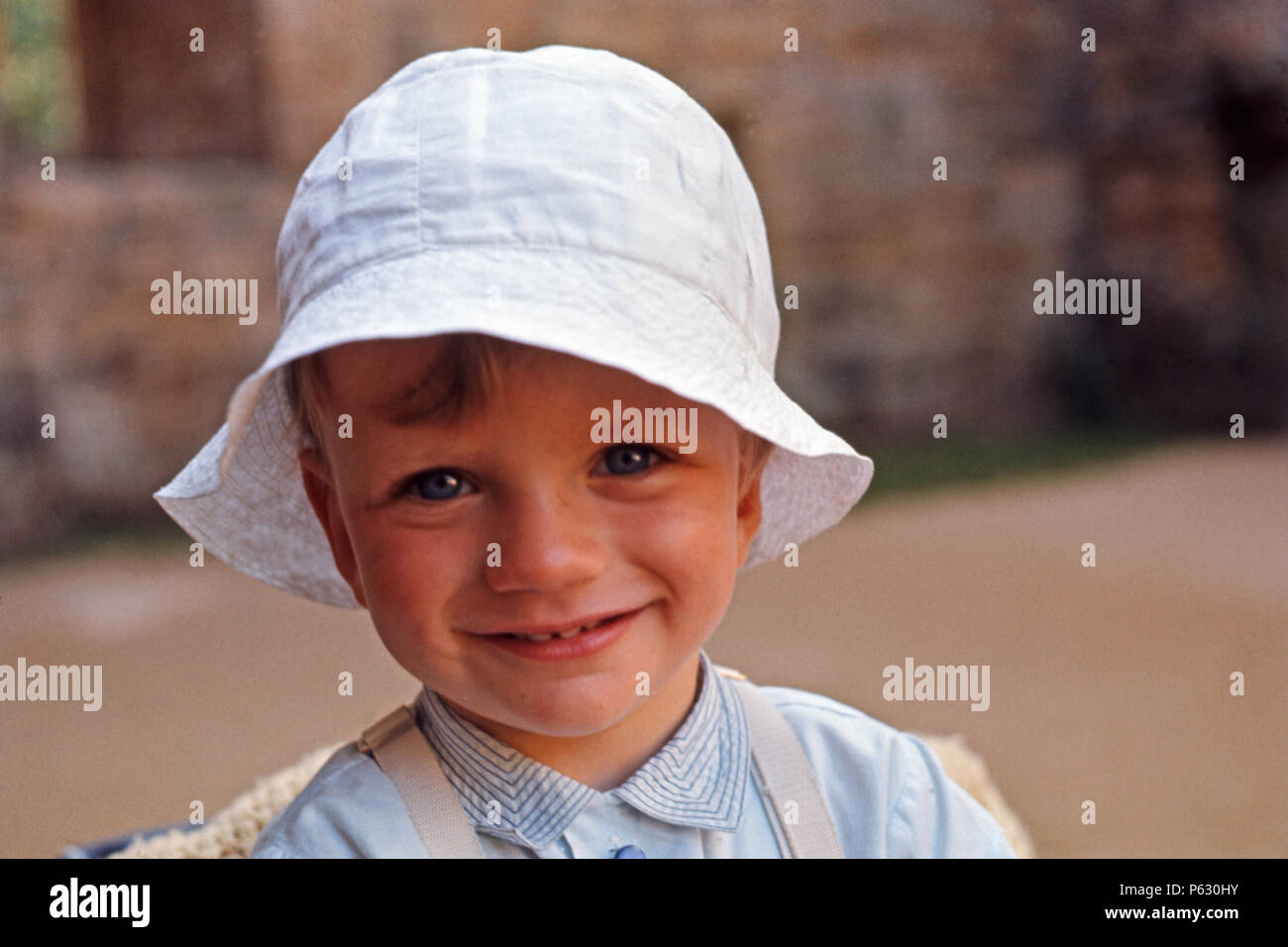 Giovane ragazzo/toddler nel cappello bianco per lo proteggono dal sole estivo, 1969 Foto Stock