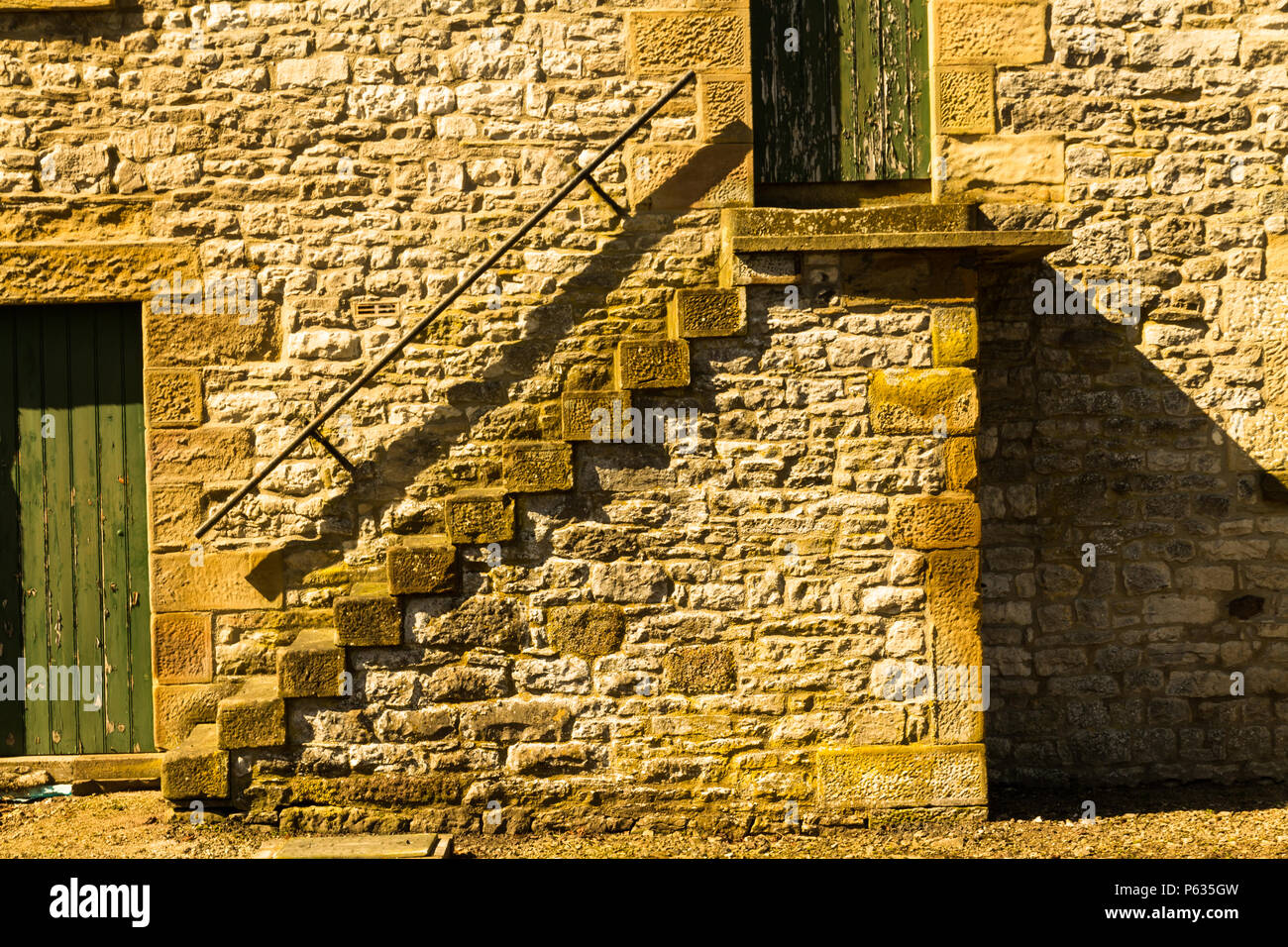 Il vecchio fienile, passi fino alla porta all'esterno. Foto Stock