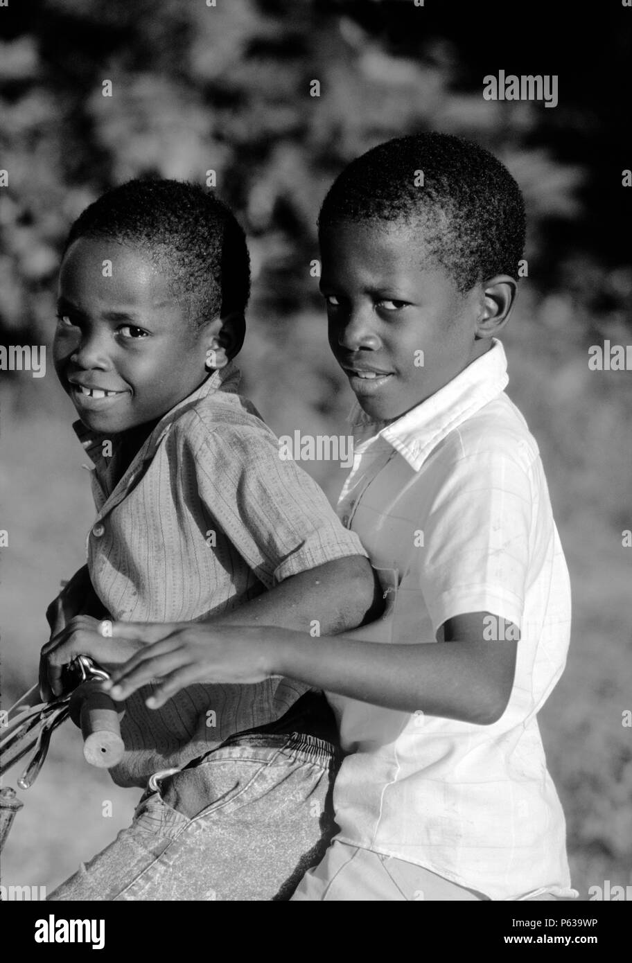 CARIB nero bambini che giocano sulla bicicletta in Punta Gorda - Roatan, isole di Bay, HONDURAS Foto Stock