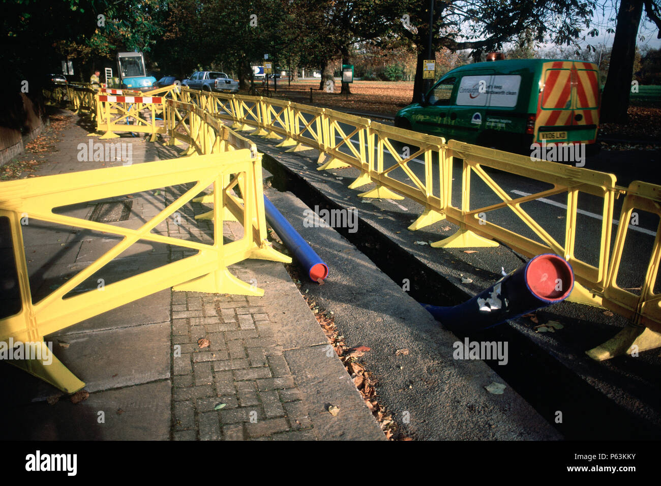 Plastica di sicurezza barriera attorno a una trincea per tubo di acqua in posa per collegamenti nazionali in Wandsworth, Londra, Regno Unito Foto Stock