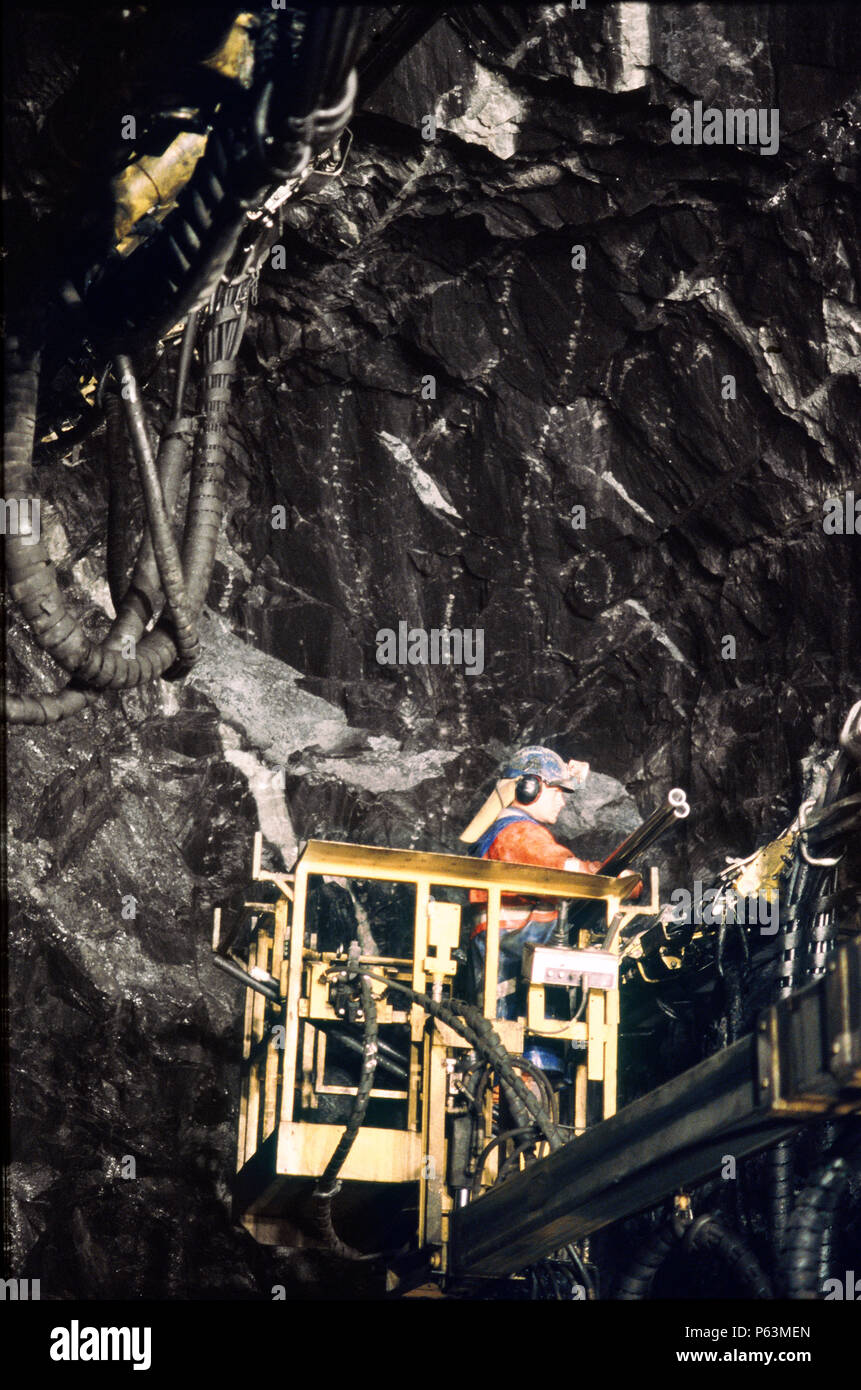 Imballaggio di un foro di carica sulla faccia della roccia di un tunnel ferroviario nel nord della Svezia Ð lavorando da un cherry picker su attrezzatura della trivella Foto Stock