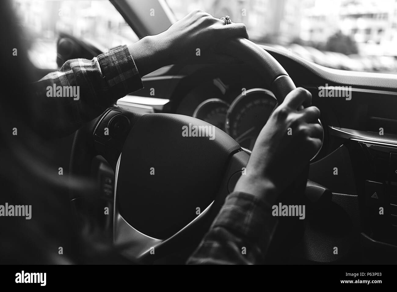 La donna in auto è la guida in bianco e nero. Foto Stock