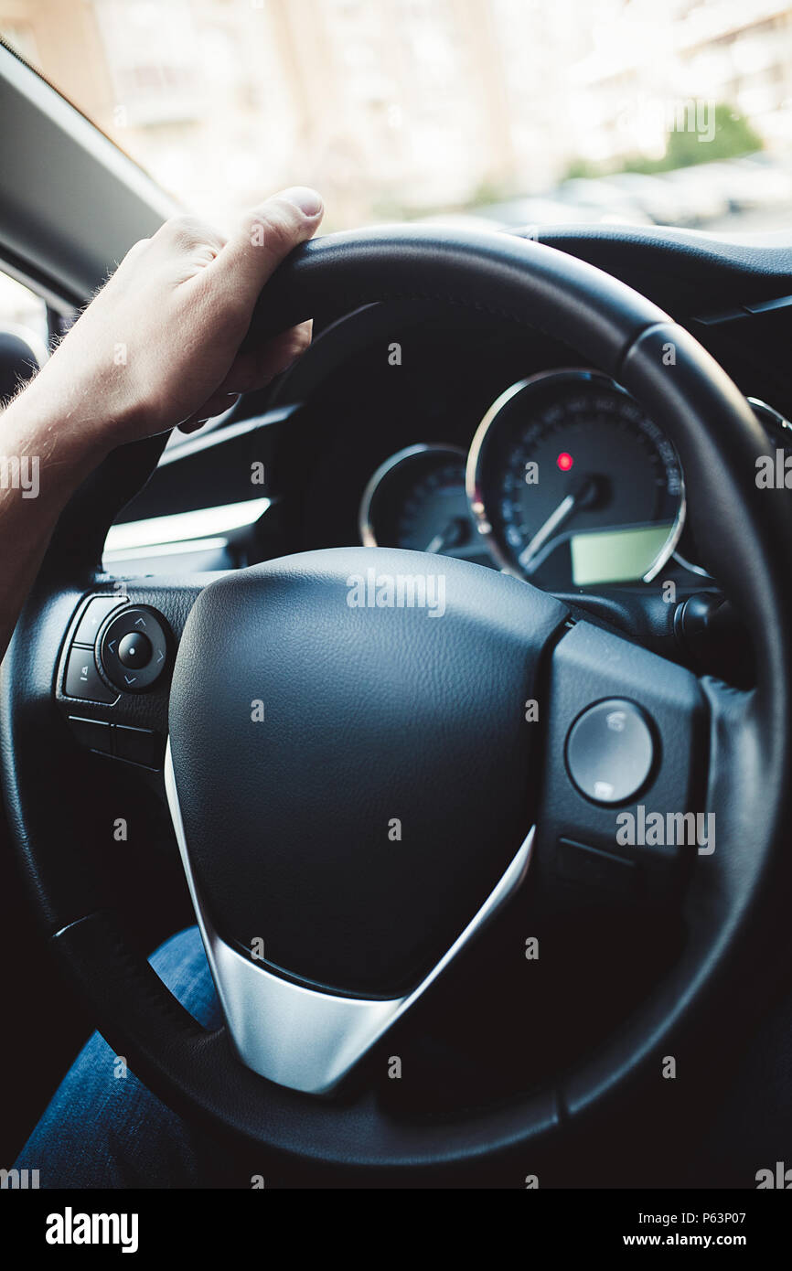Bracci maschio holding leathern del timone della vettura Foto Stock