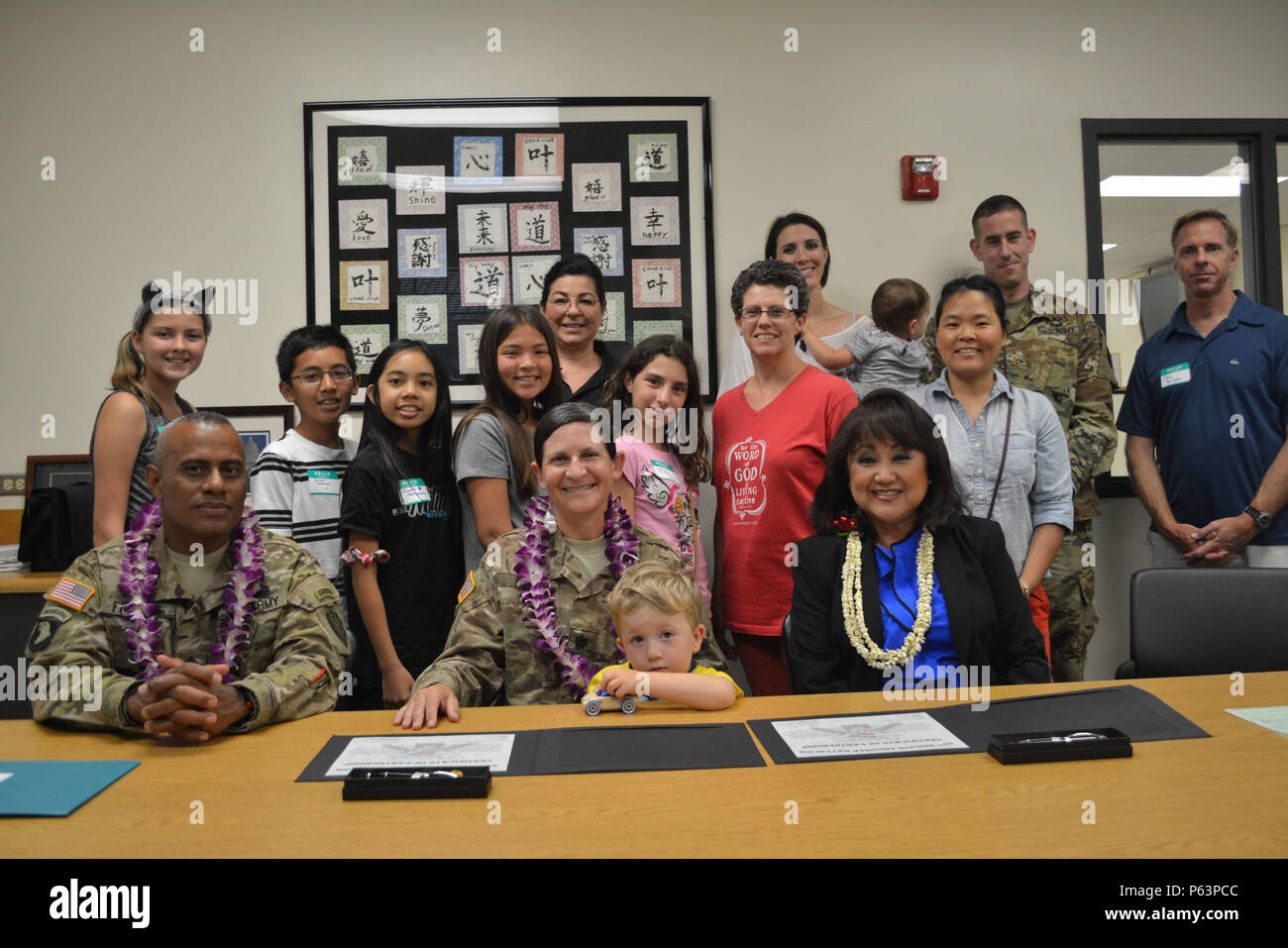 MILILANI, Hawaii - Lt. Col. Heather prelievo e il comando Sgt. Il Mag. Giovanni Fuentes, il comando team per il sessantacinquesimo ingegnere vigili del Battaglione, 2° Brigata Team di combattimento, XXV divisione di fanteria, prende una foto con Mililani's Middle School Principal, Elynne E. Chung, militare gli studenti e le loro famiglie formalmente dopo la firma di una lettera di accordo con la scuola apr. 9, 2016 a Mililani Middle School di Mililani, Hawaii. Soldati dal sessantacinquesimo BEB sono stati invitati per l annuale della scienza, tecnologia, ingegneria, matematica e istruzione (gambo) notte e discutere di come i soggetti sono utilizzati nella odierna militari. (Brevetto statunitense n. Foto Stock