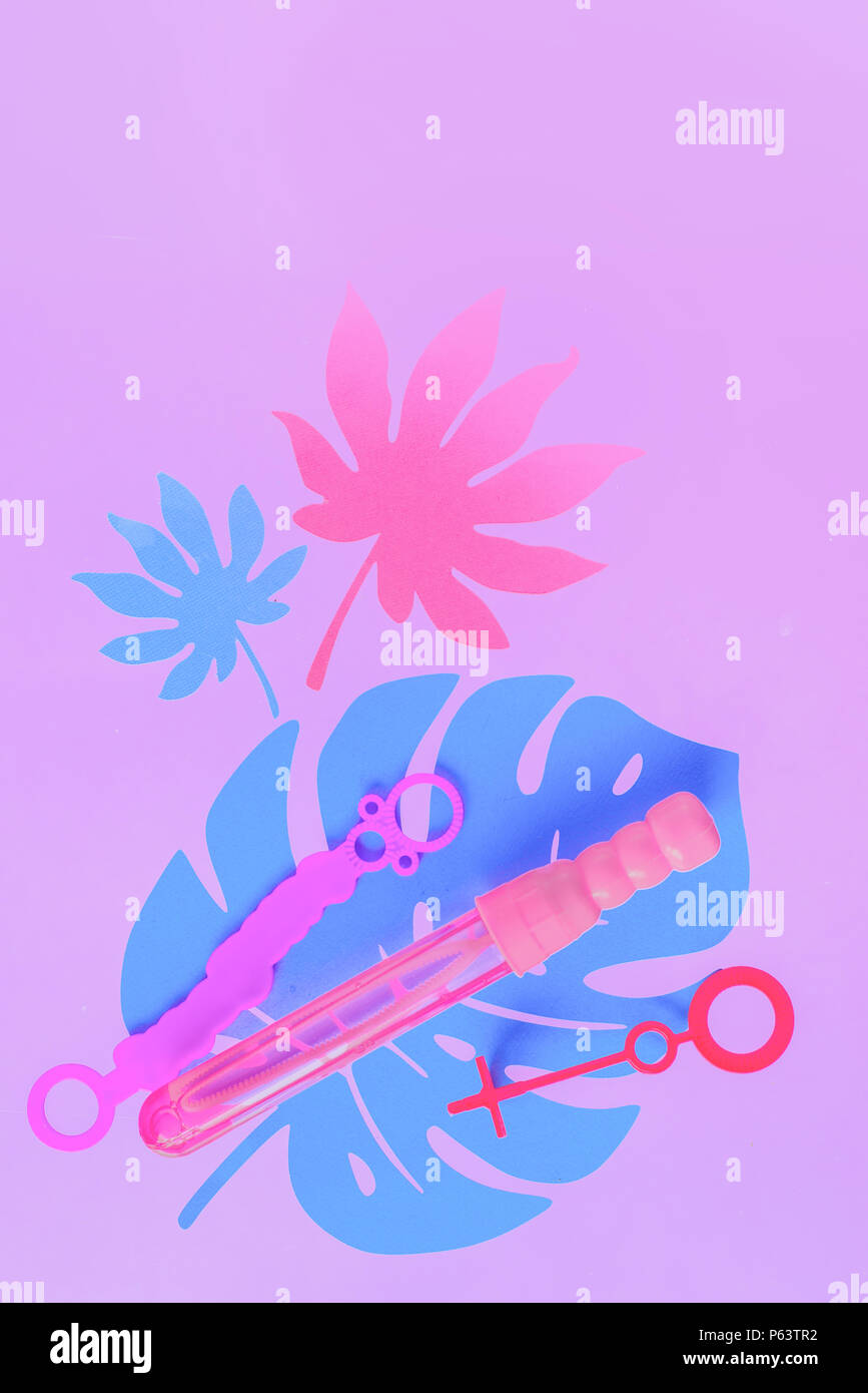 Bacchette di bolle su un pastello sfondo viola con foglie tropicali e copia di spazio. Varietà di materiali di consumo. Appartamento laici in rosa. Foto Stock