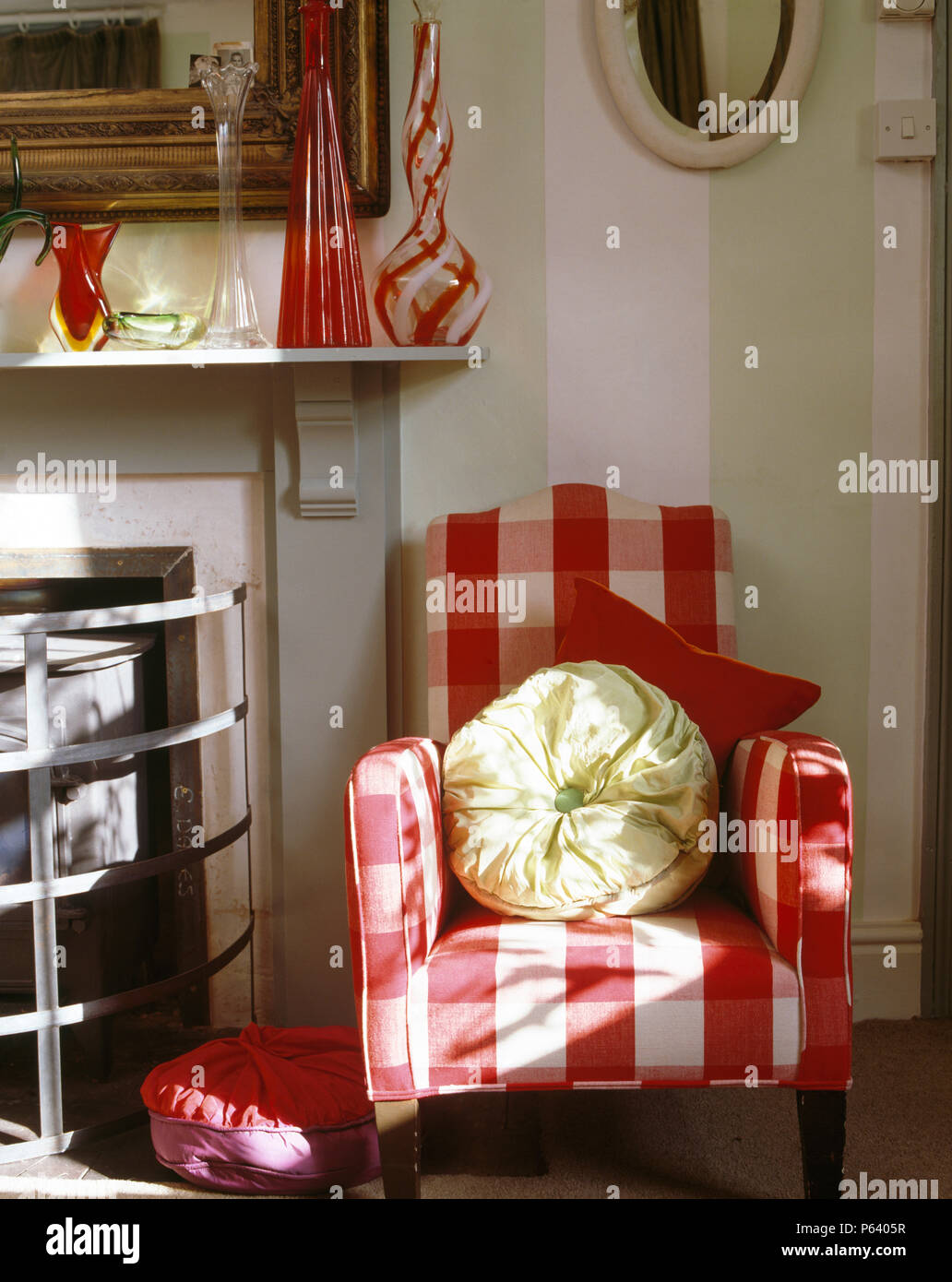 Rosso + bianco grande-verifica di poltrona accanto al caminetto nella sala countrysitting Foto Stock