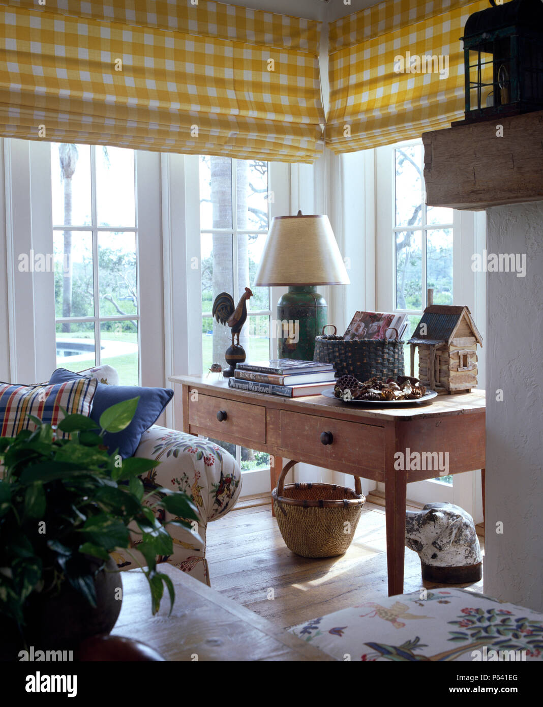 Controllare giallo cieco su finestre francesi in un luminoso e arioso paese salotto Foto Stock
