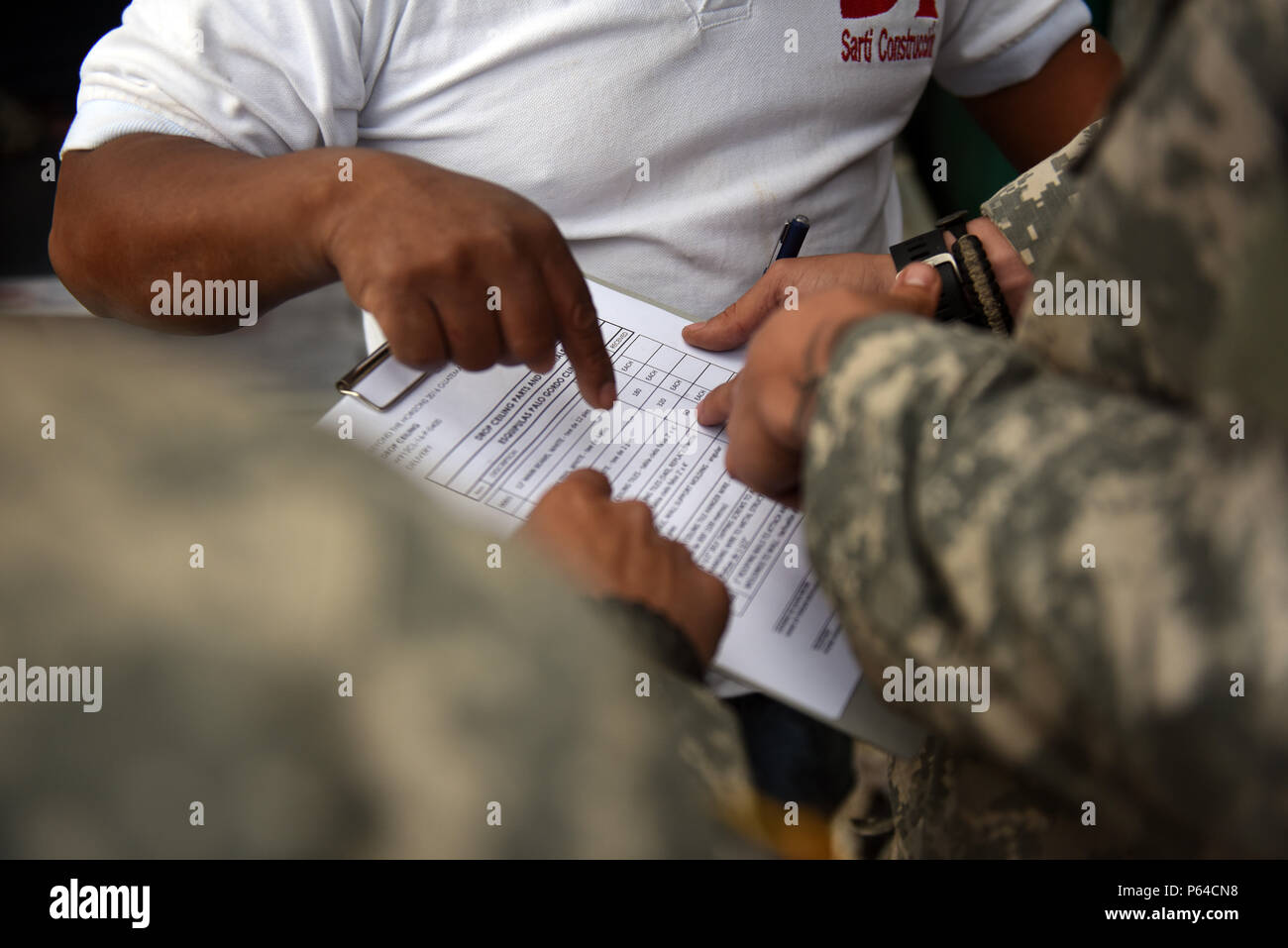 Palo Gordo, Guatemala-STATI UNITI Army Spc. Robert Gutierrez, (sinistra) 578th brigata battaglione ingegnere tecnico di combattimento, U.S. Il personale dell'esercito Sgt. Shaun Rase, (destra) 1038th ingegnere tecnico della società e Oliverio Cahuec, Guatemala materiale di costruzione fornitore dibattito sulla quantità degli articoli consegnati durante l'esercizio OLTRE L'ORIZZONTE 2016 Guatemala il 27 aprile 2016. Come appena nominato funzionario contratto rappresentante Rase è responsabile verifica forniti tutti gli elementi di costruzione. Foto Stock