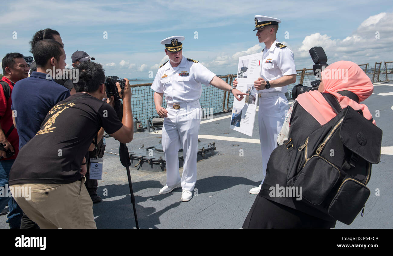 160502-N-OU129-074 MUARA base navale, Brunei (2 maggio 2016) della Cmdr. Harry Marsh, comandante della Arleigh Burke class guidato-missile destroyer USS Stethem (DDG 63), descrive le operazioni di elicottero per i membri dei media durante un tour guidato della nave 2. Il Stethem partecipa all'ASEAN il Ministro della difesa della riunione (ADMM) più la sicurezza marittima e la lotta contro il terrorismo la formazione sul campo esercizio 2016, che mira a rafforzare la cooperazione e la condivisione delle informazioni durante la sicurezza marittima e la lotta contro il terrorismo le operazioni. (U.S. Foto di Marina di Massa lo specialista di comunicazione di terza classe Joshua Fulton/ Foto Stock