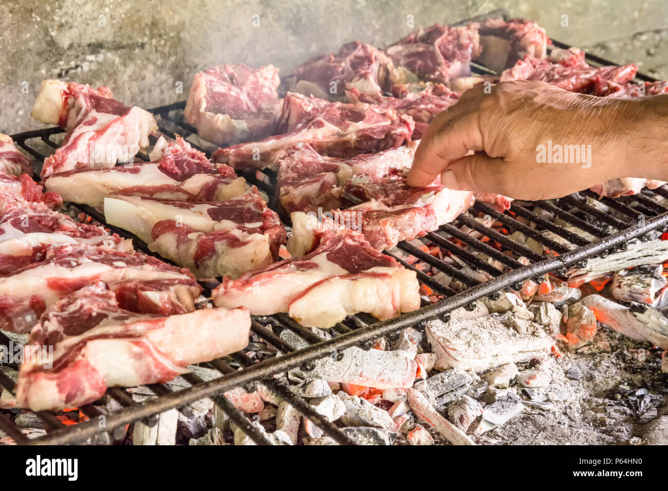 Grigliata di costolette di capra. Arrosto di carne su un barbecue in mattoni tipica barbecue in Sardegna, Italia. Messa a fuoco selettiva Foto Stock