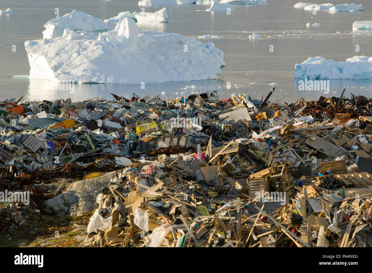 Rifiuti oggetto di dumping nella tundra al di fuori di Illulissat in Groenlandia con gli iceberg dietro dal Sermeq Kujullaq o Illulissat fiordo di ghiaccio. Il ghiaccio Illulissat Foto Stock