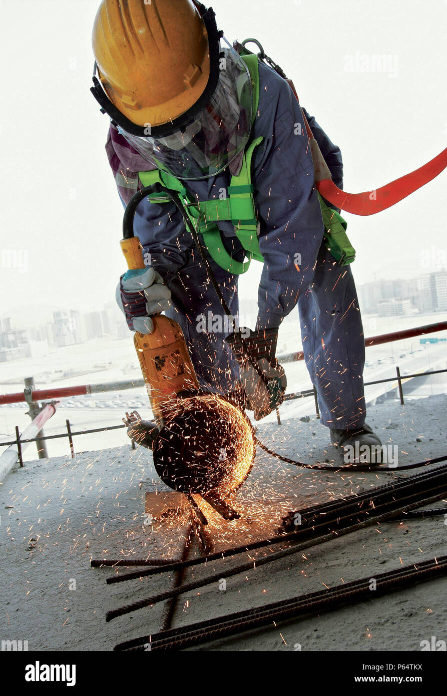 Lavoratore utilizzando strumento di potere, Dubai, Emirati Arabi Uniti, 7 marzo 2007. Foto Stock