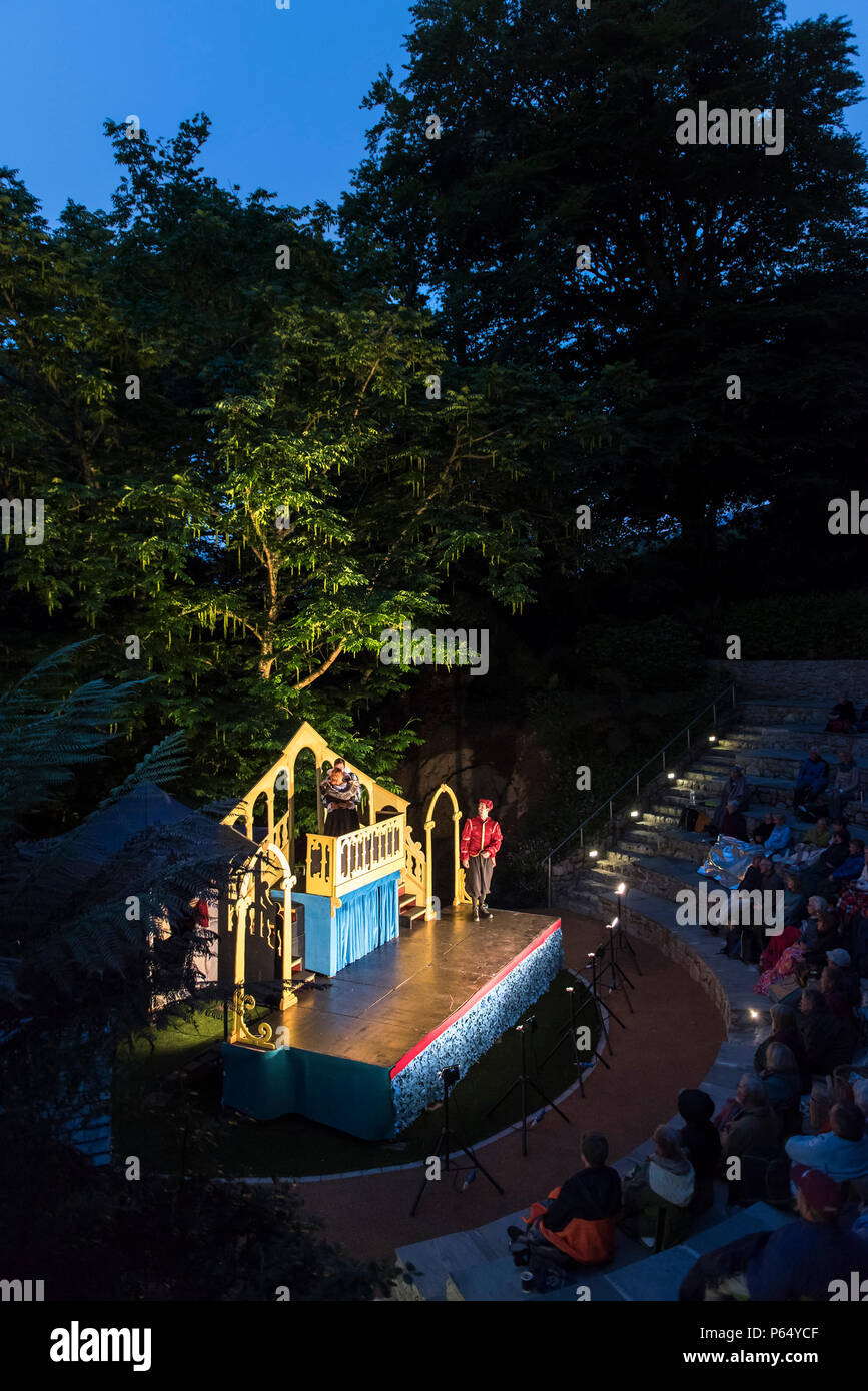 Un esterno di prestazioni del Mercante di Venezia da Illyria teatro a Trebah anfiteatro del giardino in Cornovaglia. Foto Stock